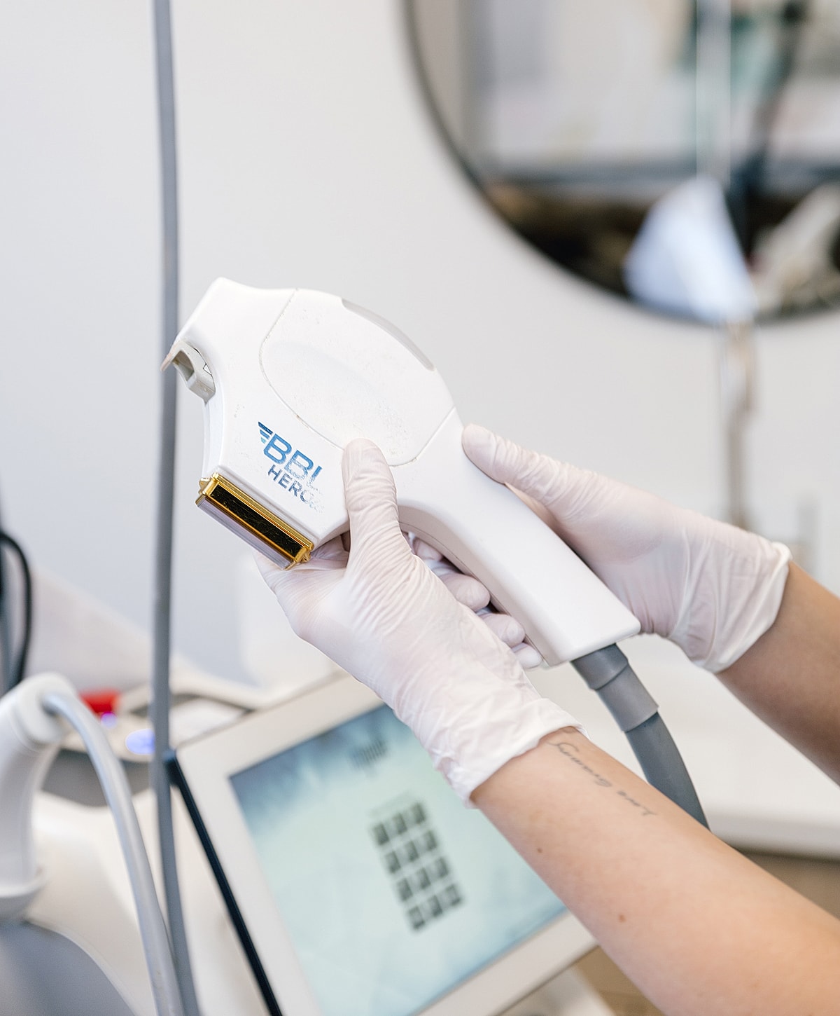 Hand holding a medical device in a treatment setting.