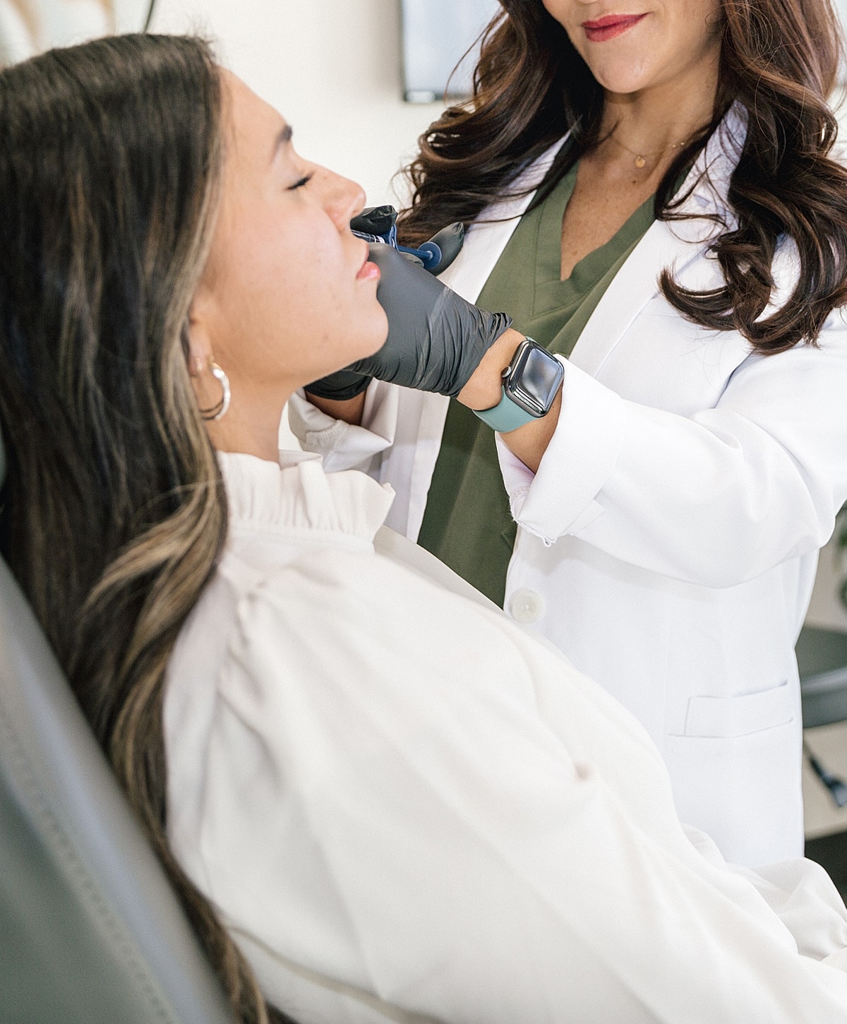 Patient receiving cosmetic treatment from professional.