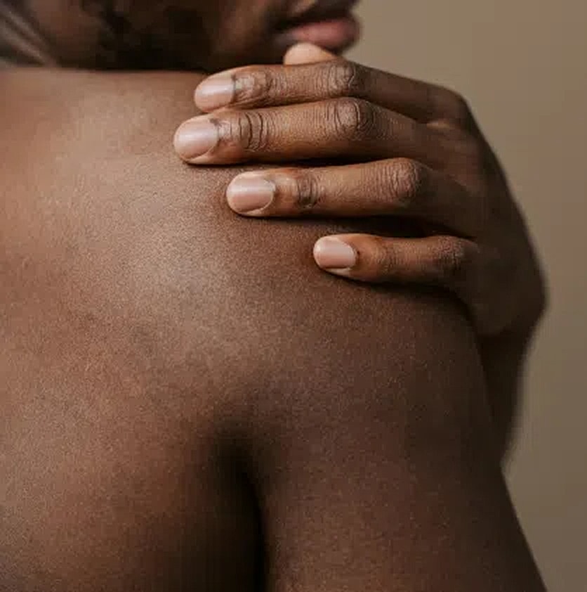 Close-up of a hand on a shoulder.