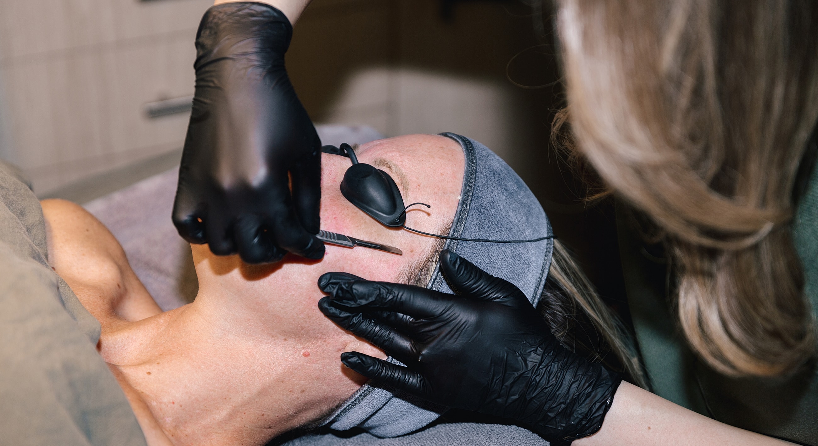 Woman receiving facial treatment in spa.